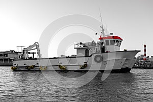 Fishing ship in harbor - selective color isolation