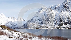 Fishing ship and snow covered mountains in Austnesfjorden in the Lofoten in winter in Norway