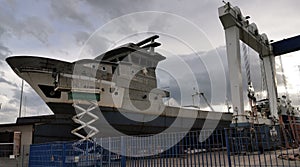 fishing ship under repair in a shipyard light reflection on metal on a day of sun and clouds winter