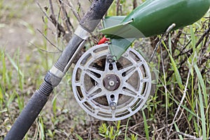 Fishing spinning lies on the grass. Fishing with a spinning reel. Close-up of fishing tackle
