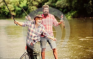 Fishing with spinning reel. Sunny summer day at river. Fisherman family. Rod tackle. Fishing equipment. Hobby sport