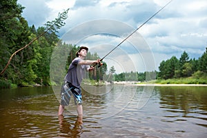 Fishing before the storm. A young man catches a fish on spinning