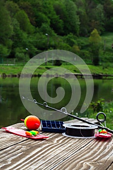 Fishing supplies on a table near a lake