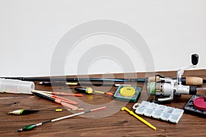 Fishing tackle - fishing rod fishing float and accessories on wooden background, copy space.