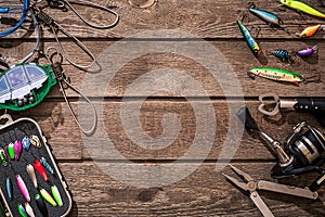 Fishing tackle - fishing spinning, fishing line, hooks and lures on wooden background.