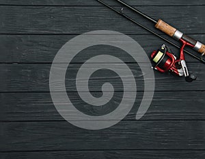 Fishing tackle - fishing spinning, hooks and lures on darken wooden background. Top view