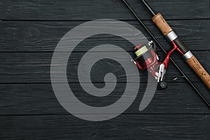 Fishing tackle - fishing spinning, hooks and lures on darken wooden background. Top view