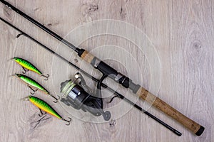 Fishing tackle - fishing spinning, hooks and lures on light wooden background.