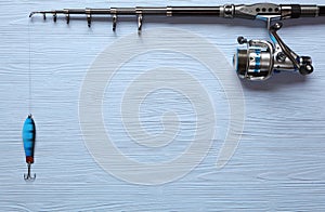 Fishing tackle - fishing spinning, hooks and lures on wooden background. photo