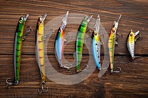 Fishing tackle - fishing spinning rod, hooks and lures on wooden background. Active hobby recreation concept