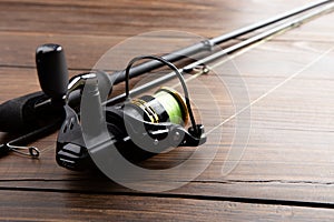 Fishing tackle - fishing spinning rod, hooks and lures on wooden background. Active hobby recreation concept