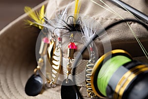 Fishing tackle - fishing spinning rod, hooks and lures on wooden background. Active hobby recreation concept