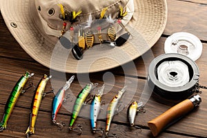 Fishing tackle - fishing spinning rod, hooks and lures on wooden background. Active hobby recreation concept