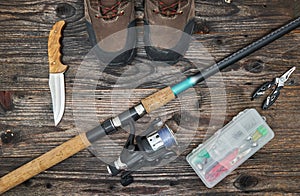 Fishing tackles and fishing gear on wooden background