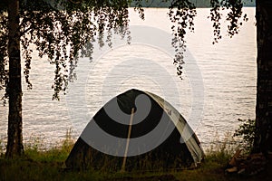 Fishing tent with a fishing rod on the shore of lake
