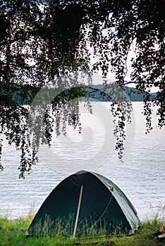 Fishing tent with a fishing rod on the shore of lake