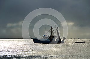 Fishing trawler boat in harbour stormy sunset