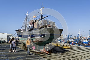 A fishing trawler sits in dry dock at the busy fishing port of Essaouira in Morocco.