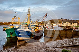 Fishing trawlers moored at Kirkcudbright harbour on the River Dee at sunset