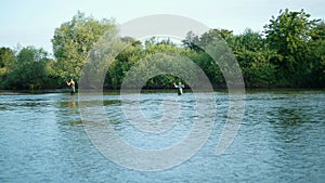 Fishing, two men fishing on the river, standing in the water, a small current