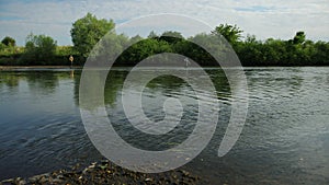 Fishing, two men fishing on the river, standing in the water, a small current