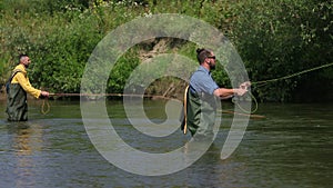 Fishing, two men fishing on the river, standing in the water, a small current