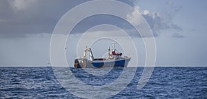 Fishing vessel during the industrial harvesting of wild marine products by deep-sea trawl