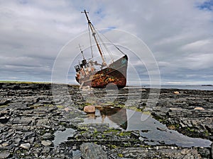 A fishing vessel thrown by a storm on the coast of the Barents Sea.