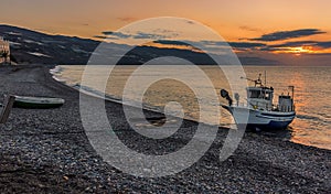 Fishing vessels moored off the beach of Castell de Ferro, Spain at sunrise