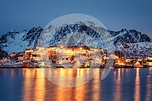 Fishing village glowing on coastline with snowy mountain at Nordland, Lofoten islands