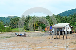 Fishing village with a house on stilts and traditional wooden bo