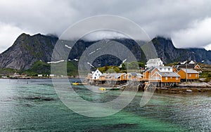 Fishing village with oragne houses on Lofoten in cloudy weather