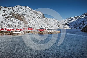 Fishing village with a pier for ships, beautiful houses painted in the national color in Norway