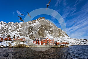 Fishing village with a pier for ships, seagulls fly over the sea, a bright sunny day