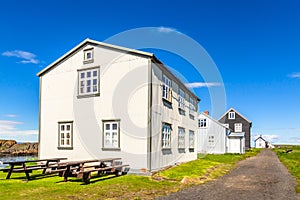 Fishing village street with living wooden houses  with blue sky in the background, Flatey island, Iceland