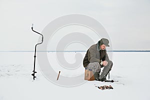 Fishing at winter. Fisherman waiting fish bite