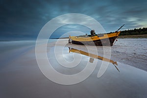 A fishing wooden boat moored by the beach, Debki, Poland