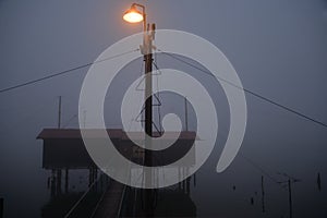 Fishing wooden hut in winter fog by night. Valli di Comacchio, Italy.