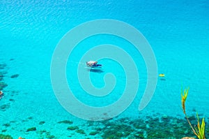 Fishing yacht and rubber boat sail drift on blue azure turquoise water surface of Tyrrhenian sea with shadows on bottom not far