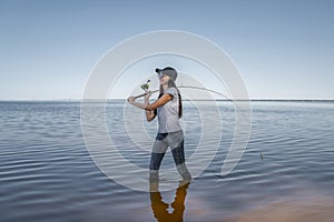 Fishing. Young fisherwoman with tackles at lake coast