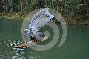 Fishman fish net in canoe