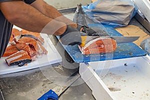 Fishmonger cutting fish into cutlets