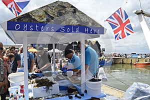 Fishmongers prepare and shuck oysters for visitors at the Whitstable Oyster Festival