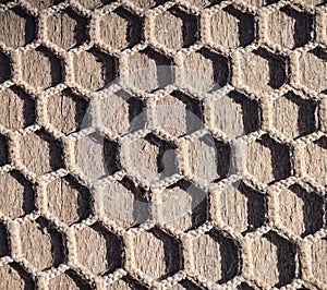Fishnet on brown wooden floor or deÑk. Mesh fabric. Fishing net background