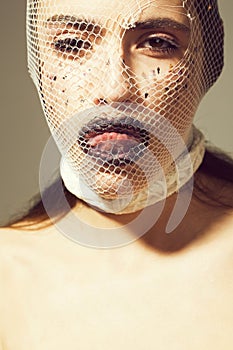 Fishnet stocking on head of girl showing tongue, black lips