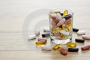 Fishoil capsules and Multivitamin supplements in the small glass