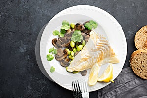 Fishplate. Sea white cod fish with a side dish of vegetables and mushrooms on a plate. Top view,