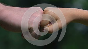 Fist bump of adult man and little boy closeup, mens friendship, family support