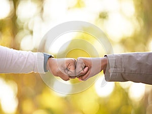 Fist bump in nature, closeup and friends show support, solidarity or partnership for victory, winning together or