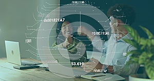 Fist-bumping colleagues wearing top and rolled-sleeves, working at office table with laptops and AR